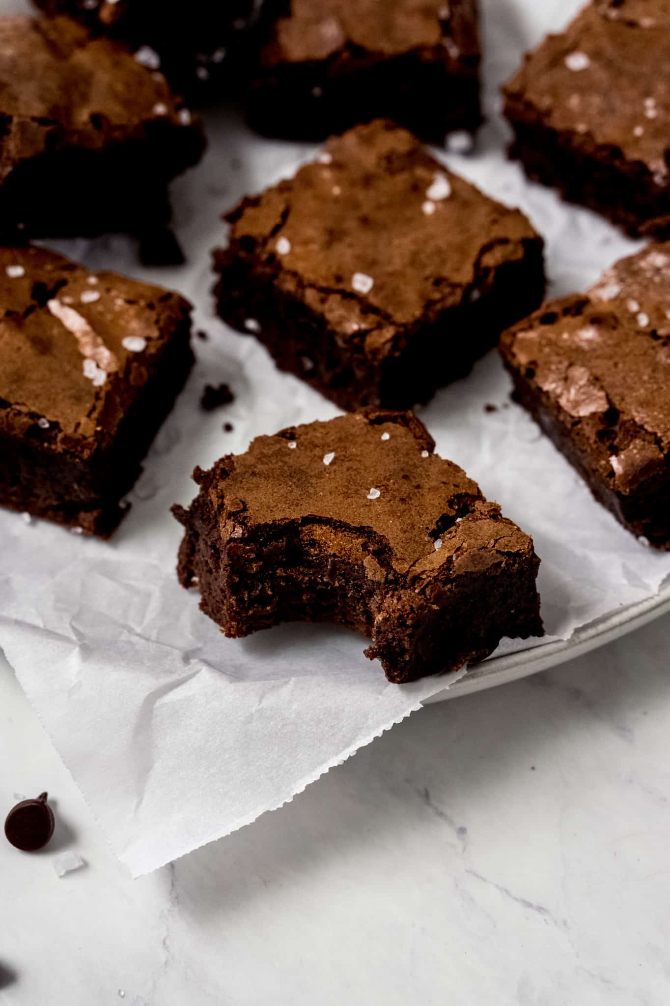 Plate of brownies with a bite mark. 