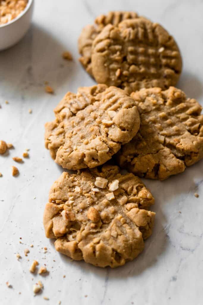 Overhead image of peanut butter cookies garnished with crushed peanuts
