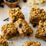 Baked banana blueberry oat bars cut into squares on a cooling rack.