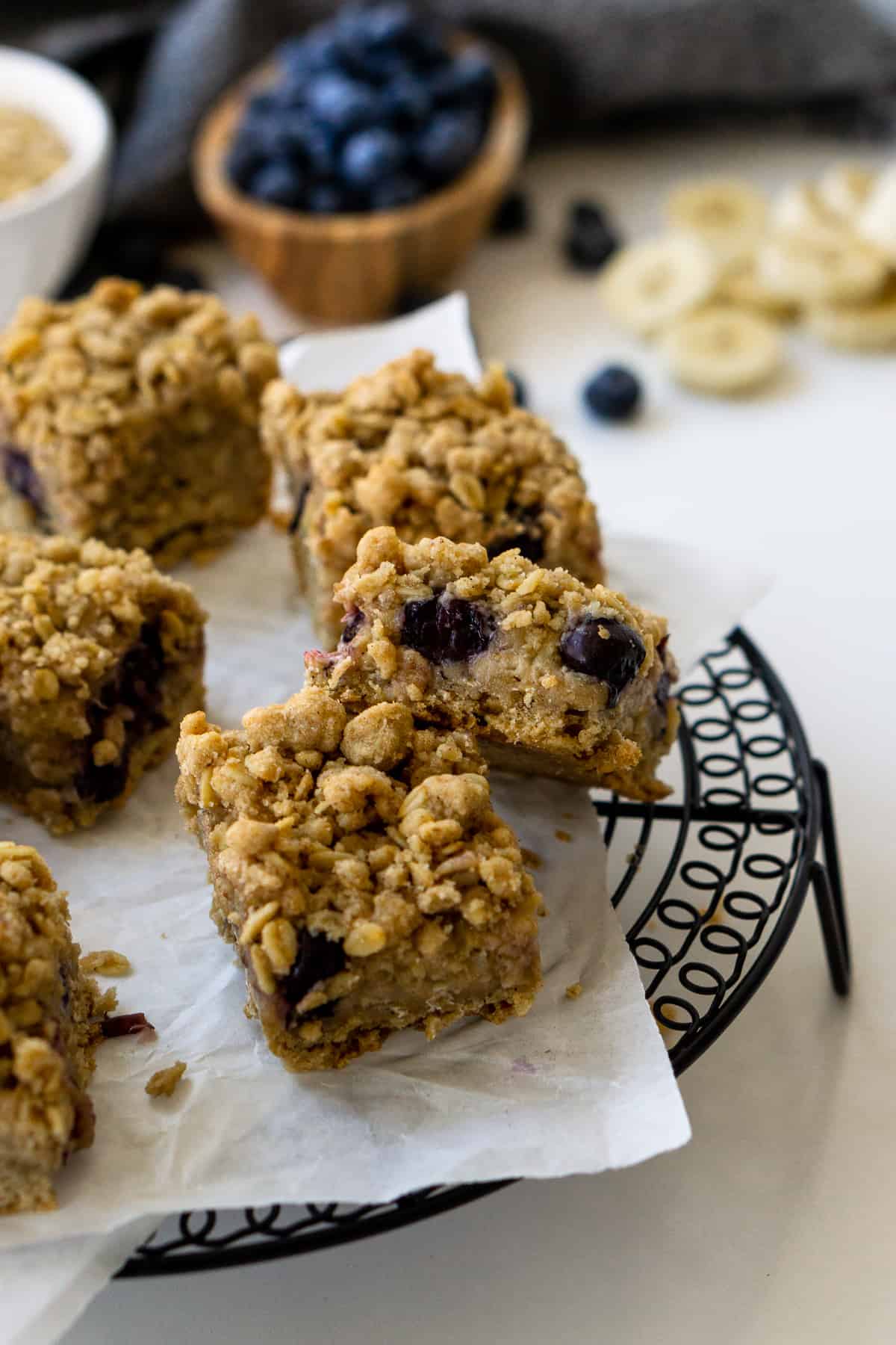 Baked banana blueberry oat bars cut into squares on a cooling rack